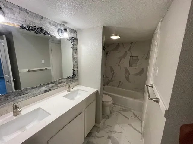 a bathroom with a sink a toilet a mirror and shower