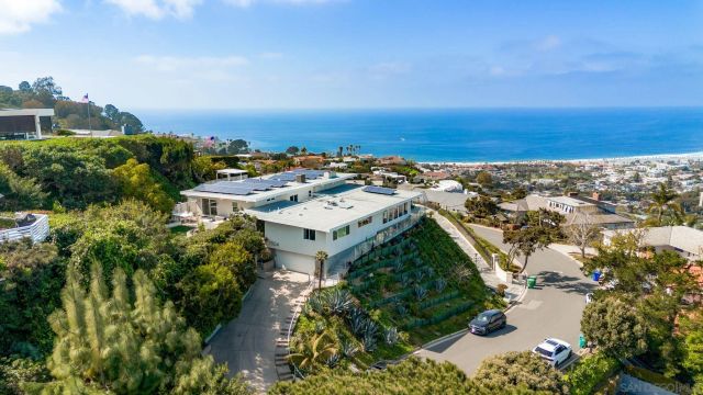 an aerial view of a house with a yard and lake view in back