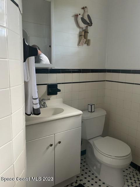 2206 Irwin Street Melbourne, FL 32901 - Photo 5 of 13 a bathroom with a sink a toilet and a mirror