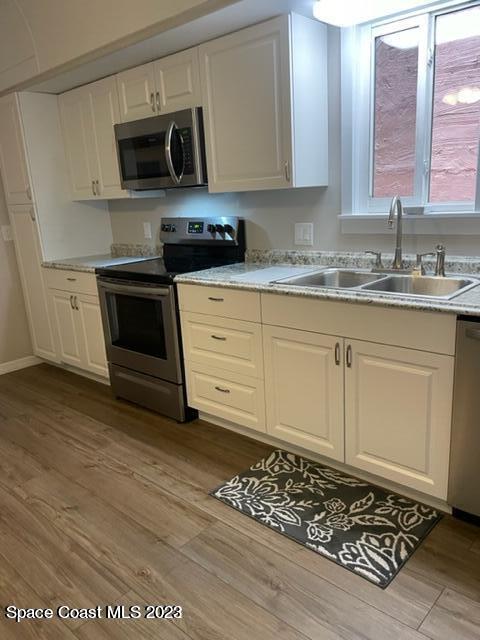 2206 Irwin Street Melbourne, FL 32901 - Photo 7 of 13 a kitchen with stainless steel appliances granite countertop a stove a sink and a microwave