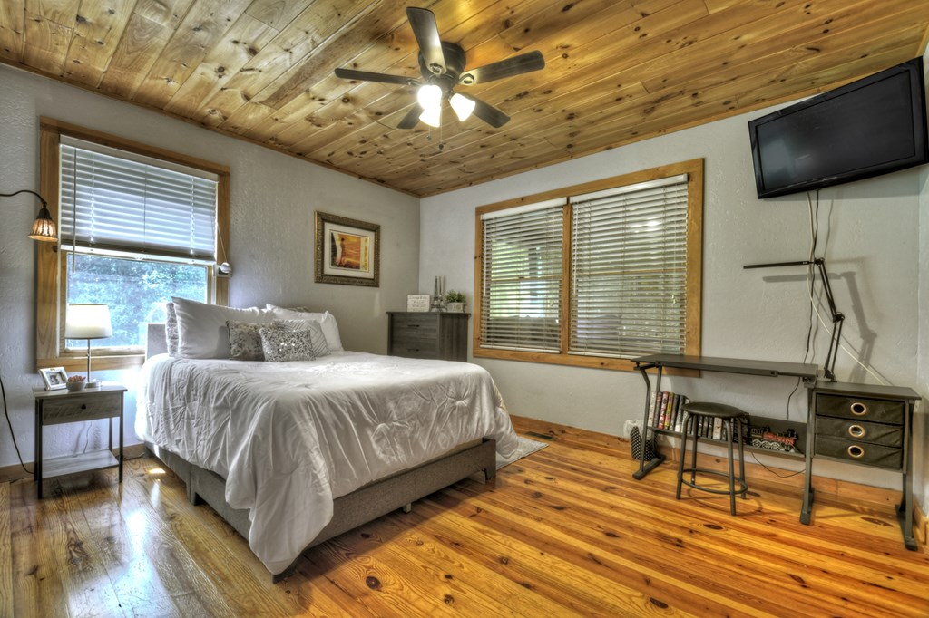 241 Dunn Mill Creek Road Blue Ridge, GA 30513 - Photo 17 of 97 a bedroom with a bed a table and chairs with wooden floor
