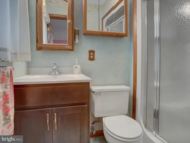 a bathroom with a sink vanity mirror and toilet