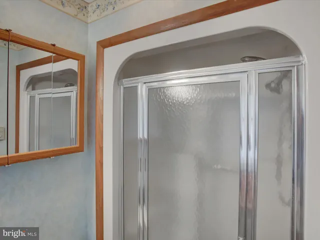 a bathroom with a glass shower door and a mirror