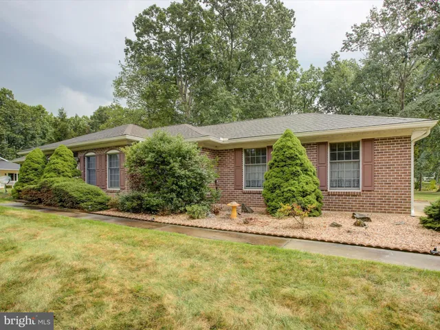 a front view of house with yard and trees around