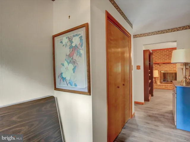 a view of a hallway with wooden floor and windows