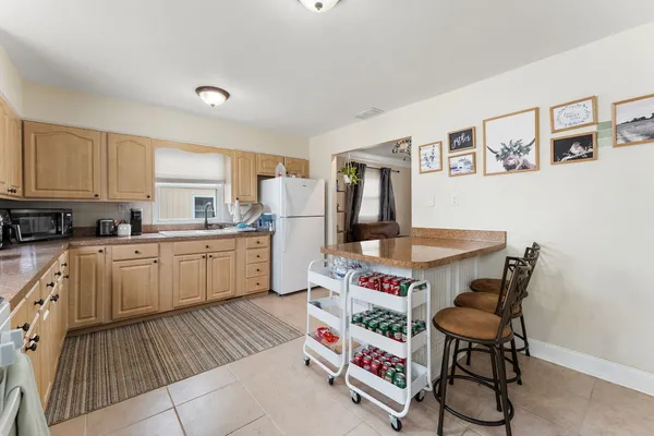 a open kitchen with stainless steel appliances granite countertop a stove top oven a sink dishwasher and cabinets with wooden floor