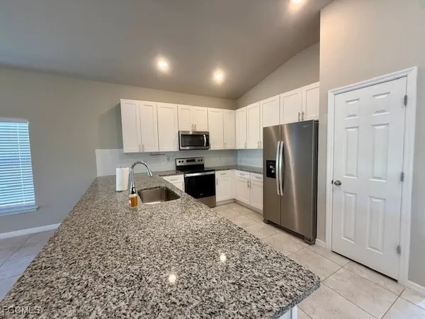 a kitchen with stainless steel appliances granite countertop a refrigerator sink and stove