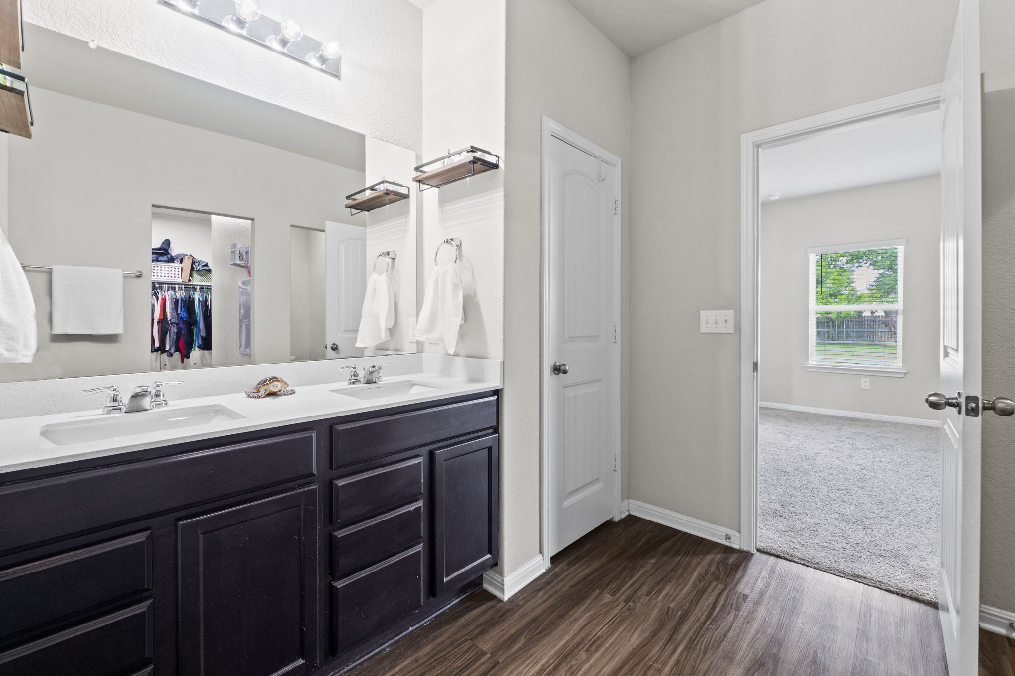 2417 Bridges Ranch Road Georgetown, TX 78628 - Photo 29 of 36 Bathroom featuring double vanity, dark wood-style flooring, and a spacious closet