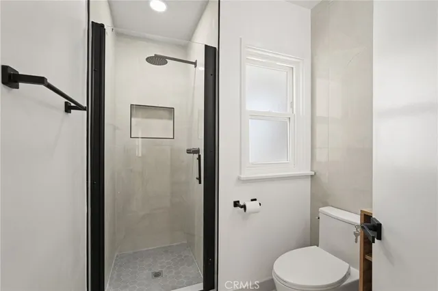 a large kitchen with stainless steel appliances granite countertop a refrigerator a sink dishwasher a stove and a refrigerator with wooden floor