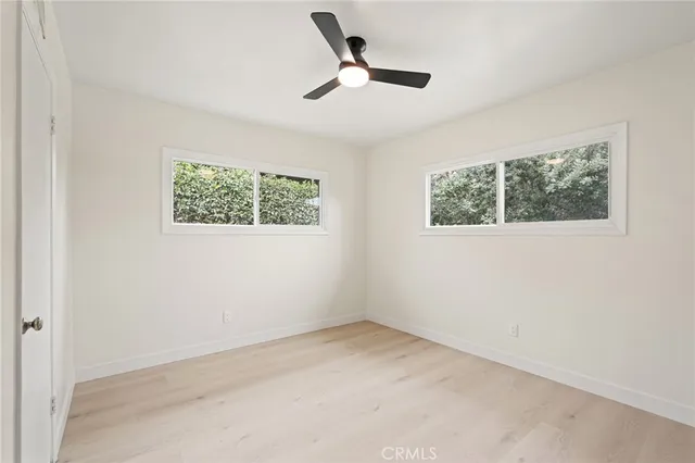 an empty room with fan and windows