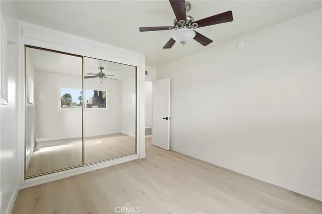 an empty room with windows and fan