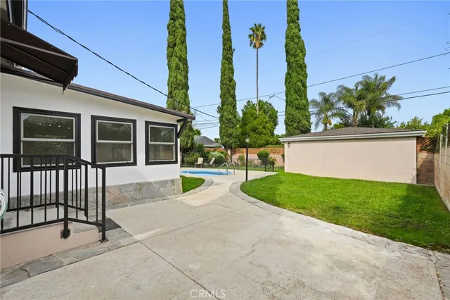 a view of a house with backyard and a garden