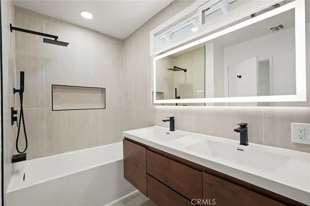 a bathroom with a sink a mirror and a bathtub