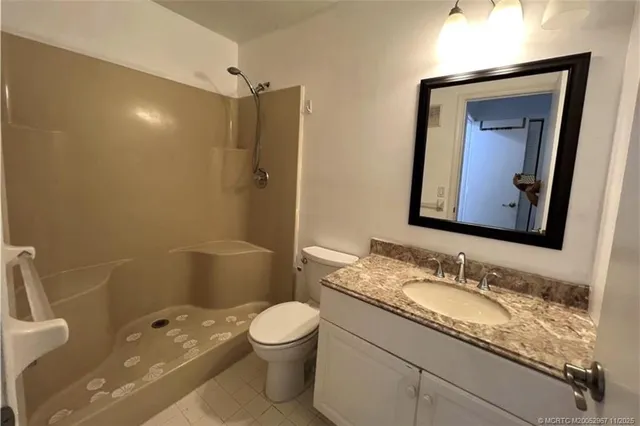 a bathroom with a granite countertop sink toilet and shower