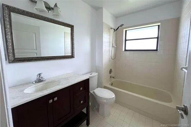 a bathroom with a double vanity sink toilet mirror and bathtub