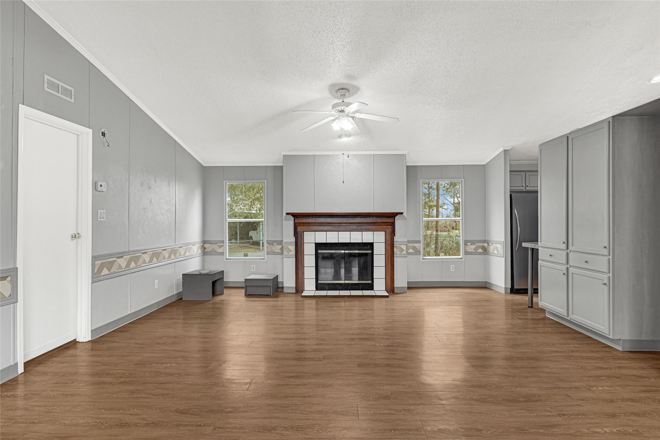 3725 Allen Road Pearland, TX 77584 - Photo 22 of 43 a view of a livingroom with a fireplace a ceiling fan and windows