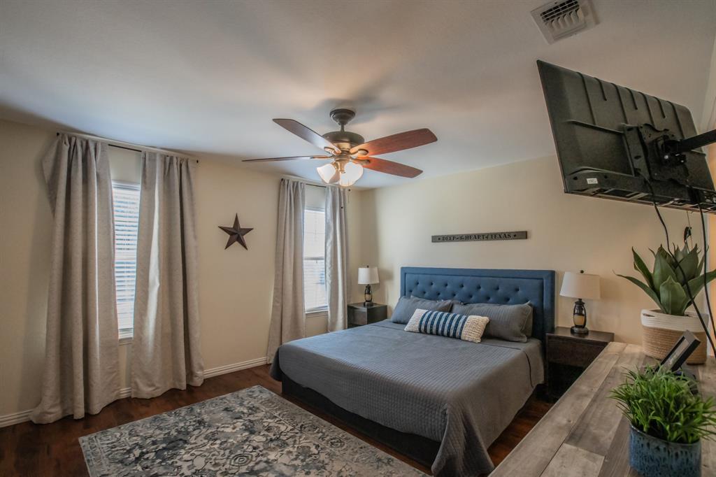 6801 Sandshell Boulevard Fort Worth, TX 76137 - Photo 11 of 28 a bedroom with a bed and a chandelier