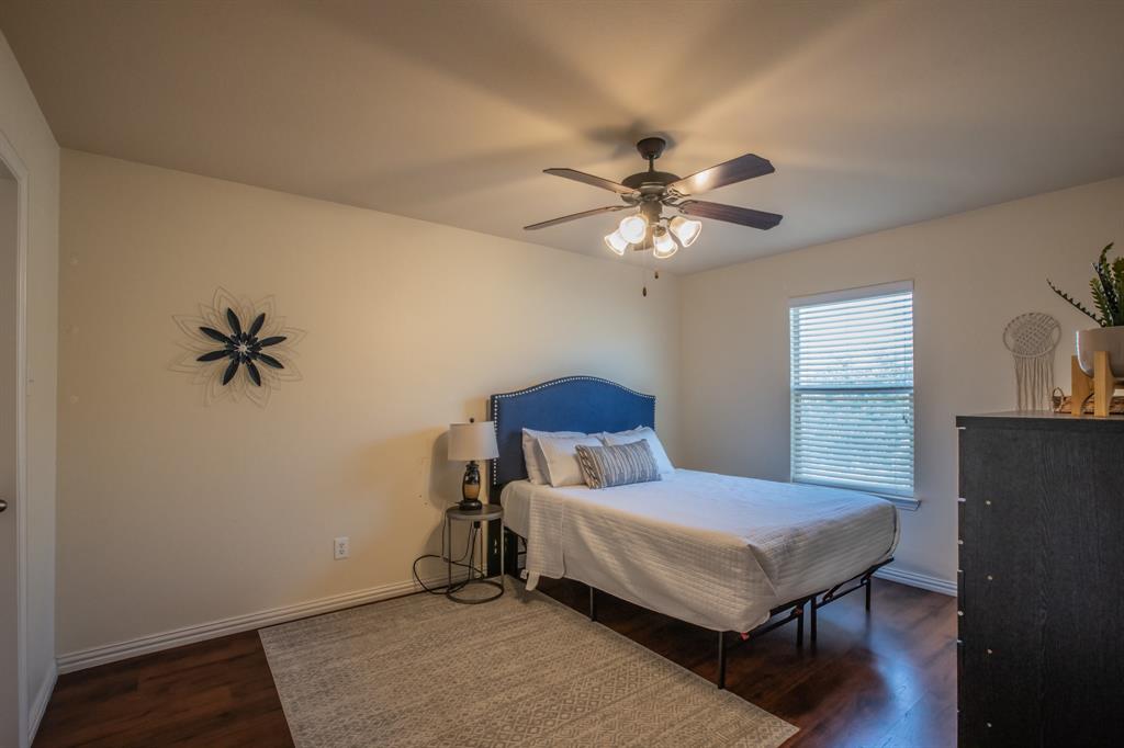 6801 Sandshell Boulevard Fort Worth, TX 76137 - Photo 21 of 28 a bedroom with a bed and a chandelier