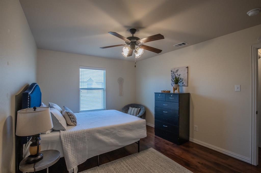 6801 Sandshell Boulevard Fort Worth, TX 76137 - Photo 22 of 28 a bedroom with a bed and a chandelier