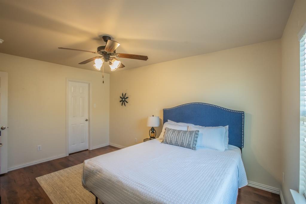 6801 Sandshell Boulevard Fort Worth, TX 76137 - Photo 23 of 28 a bedroom with a bed and a chandelier
