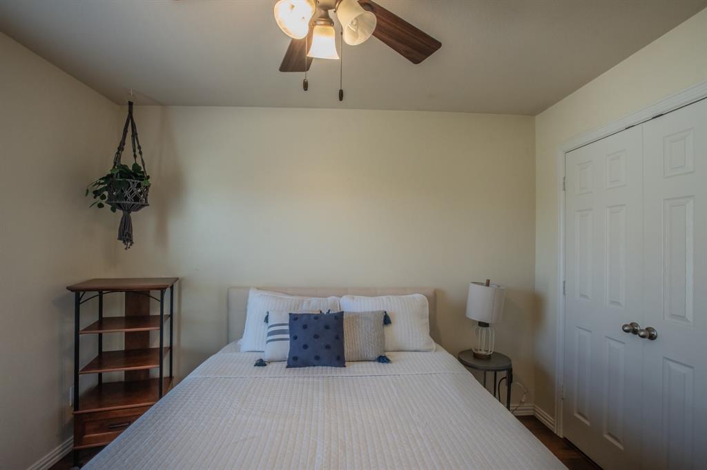 6801 Sandshell Boulevard Fort Worth, TX 76137 - Photo 25 of 28 a bedroom with a bed and a chandelier