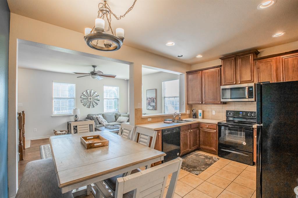 6801 Sandshell Boulevard Fort Worth, TX 76137 - Photo 6 of 28 a kitchen with a refrigerator a stove a sink dishwasher a dining table and chairs with wooden floor
