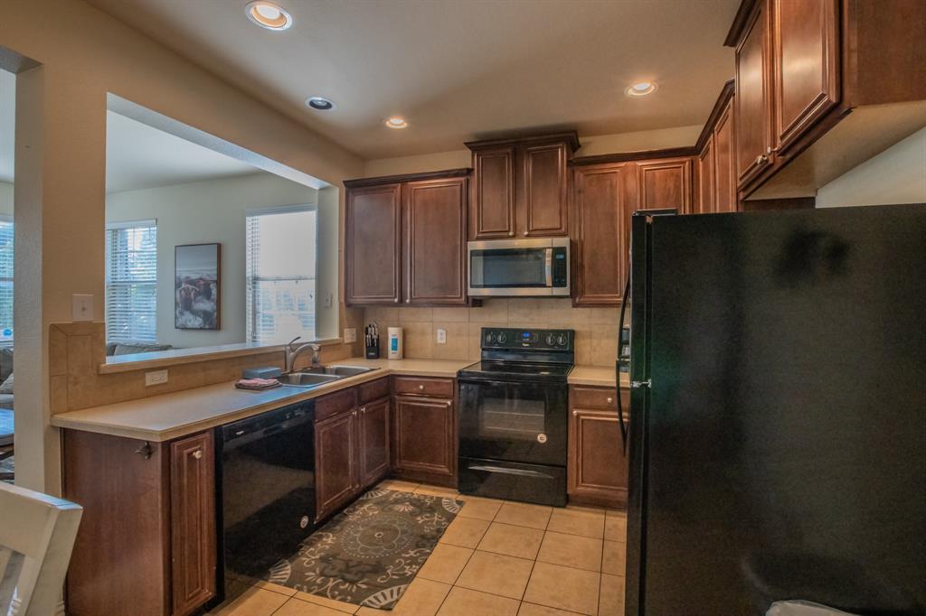 6801 Sandshell Boulevard Fort Worth, TX 76137 - Photo 10 of 28 a kitchen with a sink stove and refrigerator