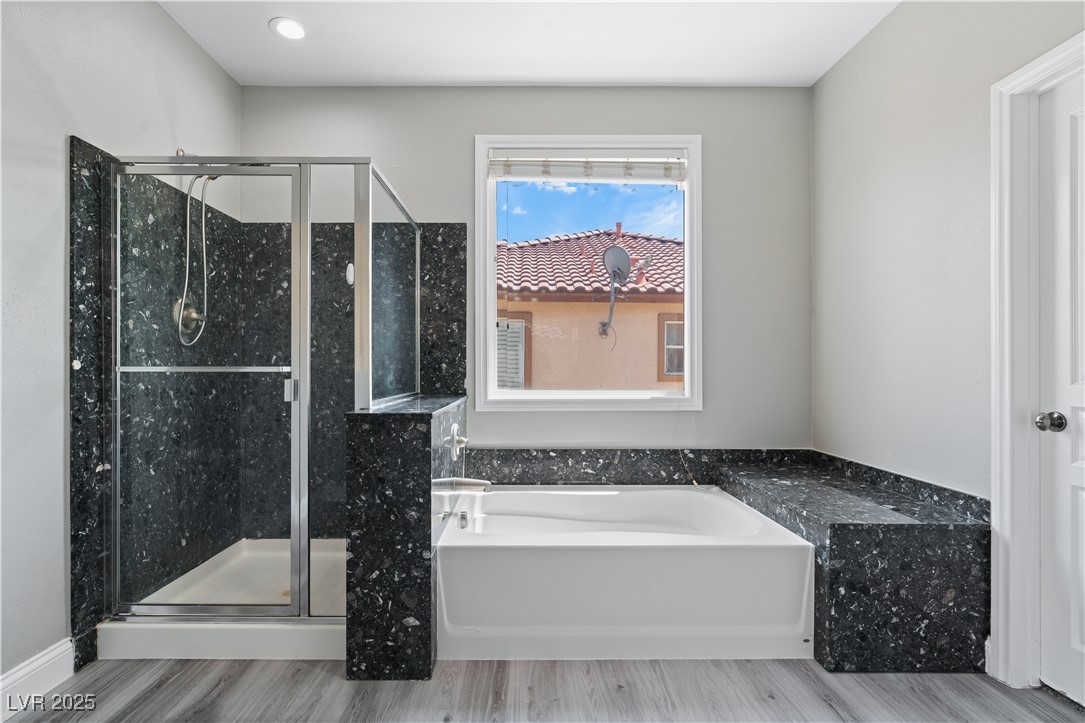 312 Pocono Ranch Avenue North Las Vegas, NV 89031 - Photo 20 of 34 Bathroom with a garden tub, a shower stall, and wood finished floors