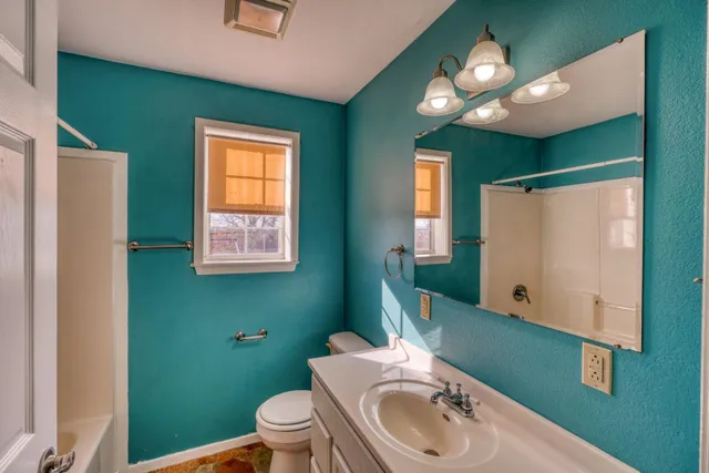 a bathroom with a sink a toilet and mirror