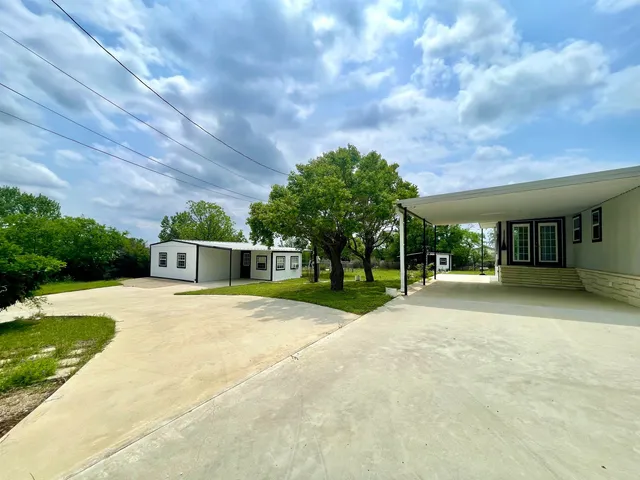 a front view of a house with a yard and trees