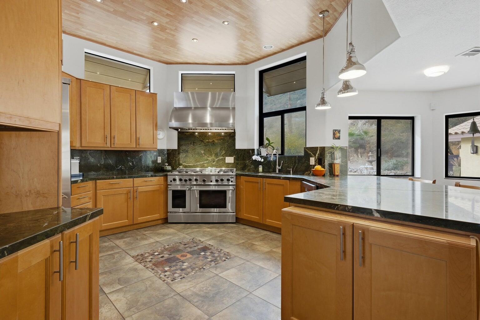 10 Venus Drive Rancho Mirage, CA 92270 - Photo 19 of 32 a kitchen with stainless steel appliances granite countertop a stove a sink and a refrigerator