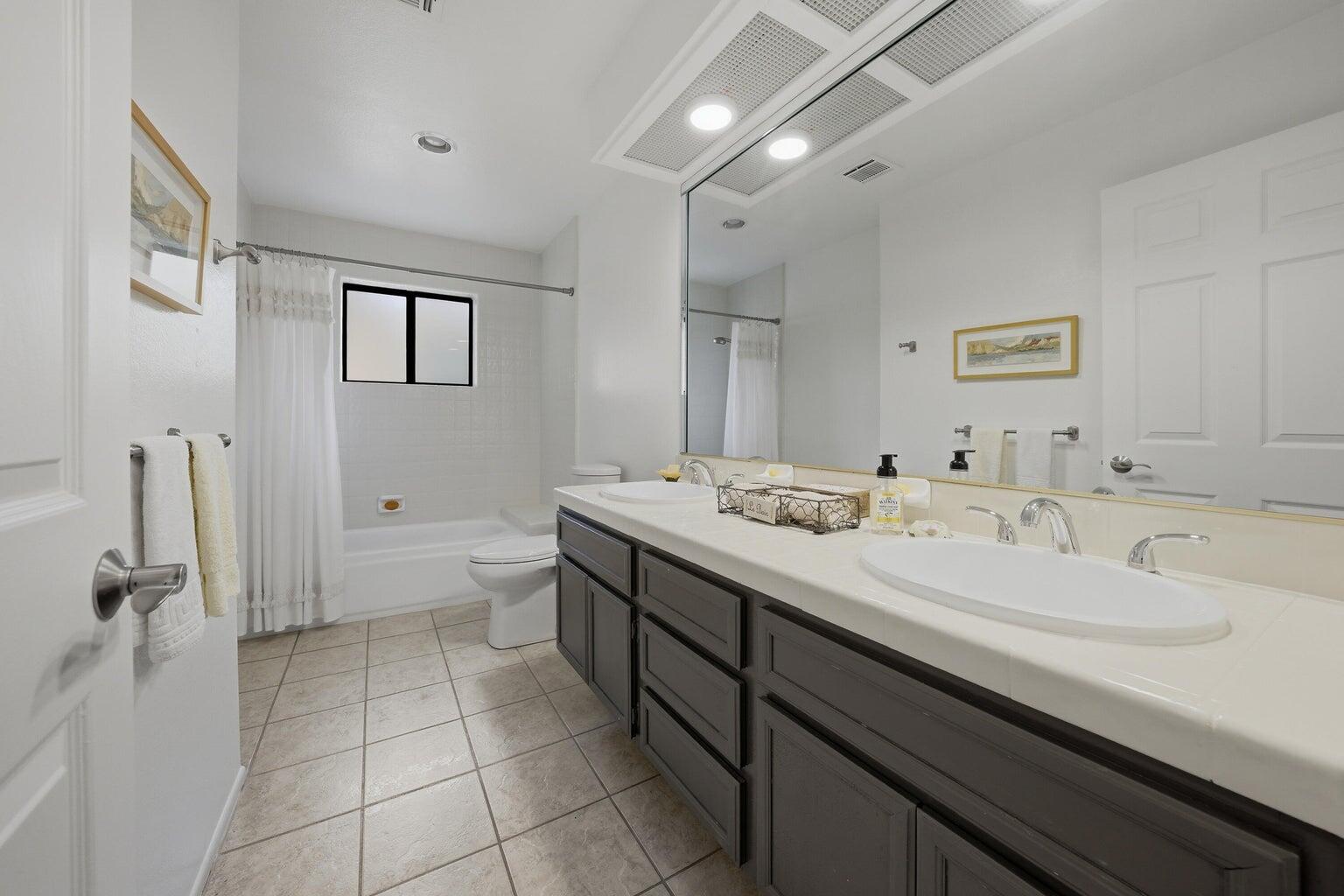 10 Venus Drive Rancho Mirage, CA 92270 - Photo 26 of 32 a spacious bathroom with a granite countertop sink a toilet and a mirror