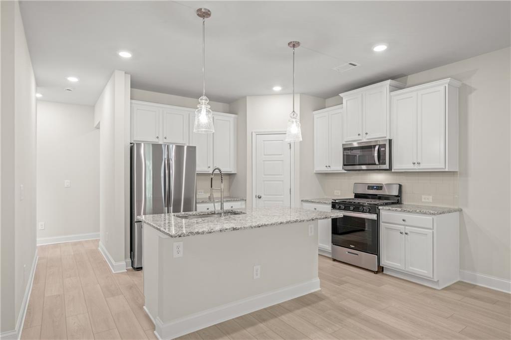 32 Station Overlook Way Auburn, GA 30011 - Photo 13 of 38 a kitchen with stainless steel appliances granite countertop a sink a stove a refrigerator and cabinets