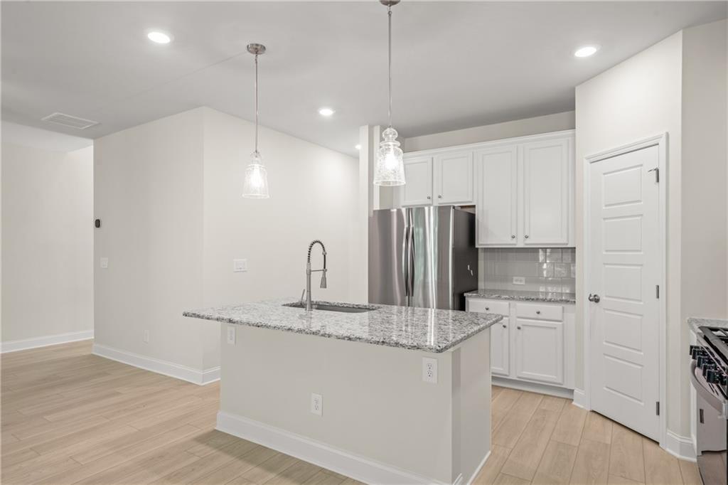 32 Station Overlook Way Auburn, GA 30011 - Photo 14 of 38 a kitchen with kitchen island a sink stainless steel appliances and cabinets