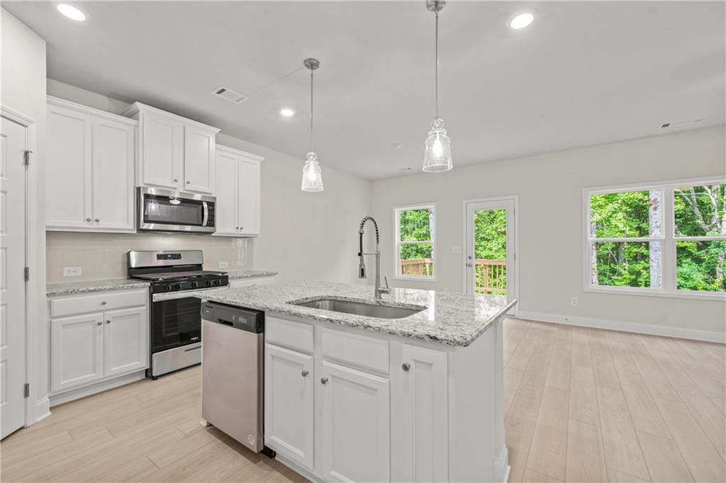 32 Station Overlook Way Auburn, GA 30011 - Photo 15 of 38 a kitchen with granite countertop white cabinets and white appliances