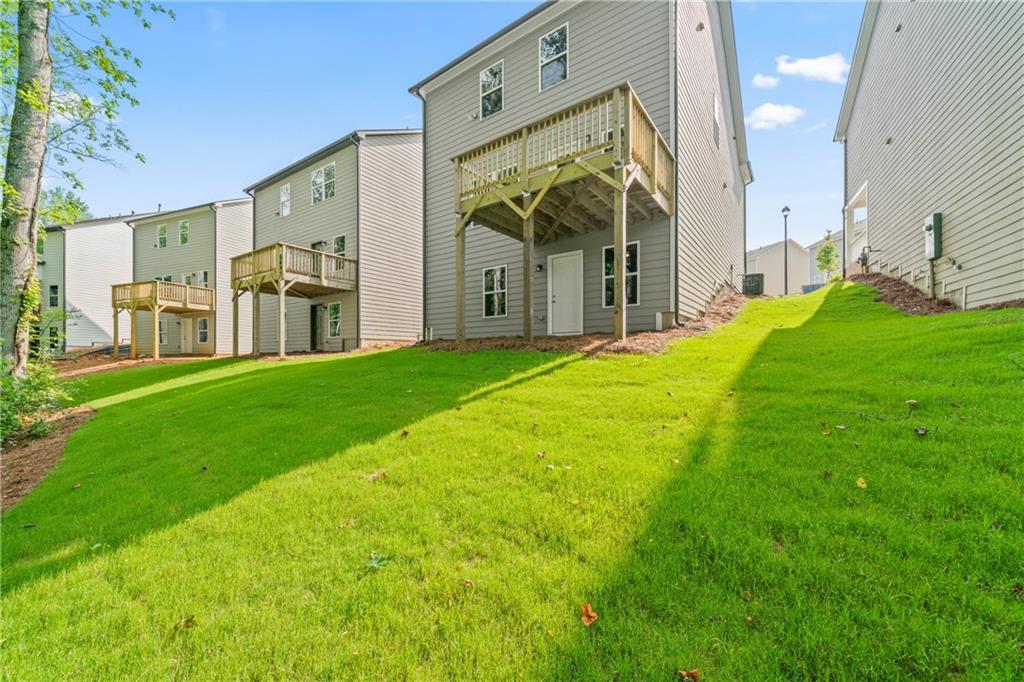 32 Station Overlook Way Auburn, GA 30011 - Photo 36 of 38 a view of a white house with a big yard and large tree