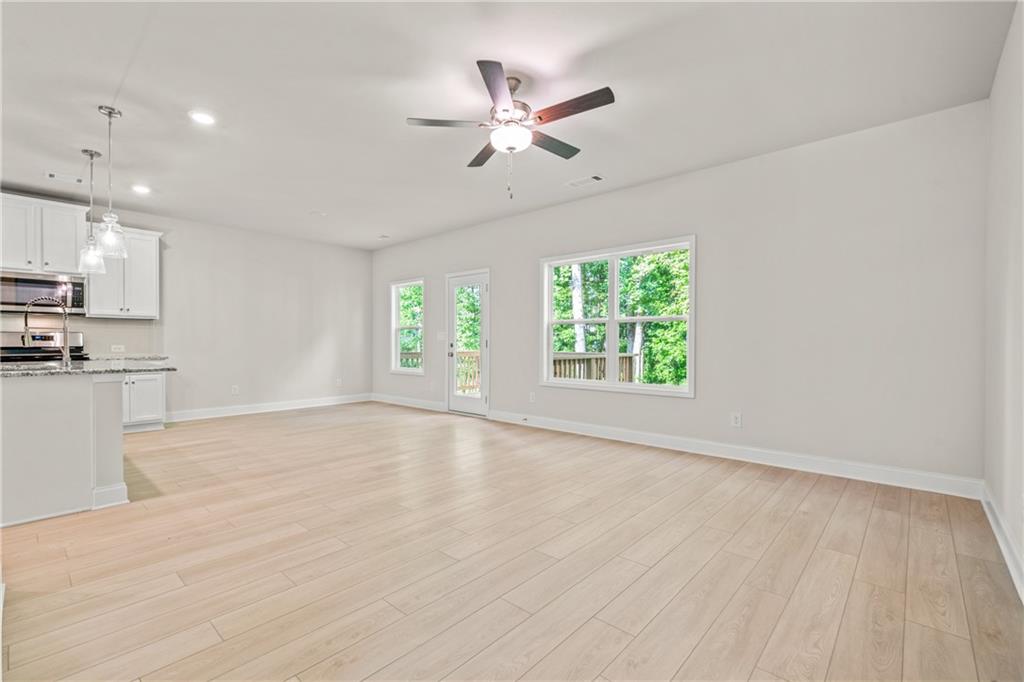 32 Station Overlook Way Auburn, GA 30011 - Photo 5 of 38 an empty room with wooden floor fan and windows