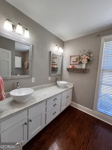 an empty room with windows fireplace and wooden floor