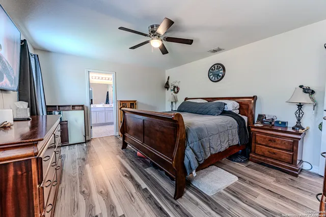 a bedroom with a bed and a flat tv screen on dresser