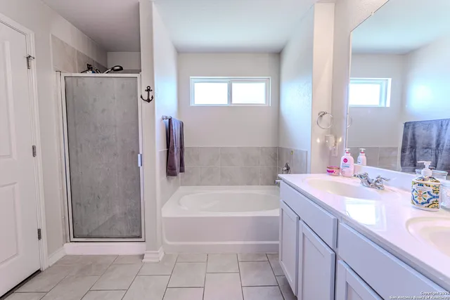 a bathroom with a tub sink and mirror