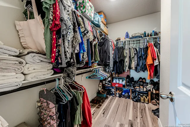 a view of walk in closet with clothes