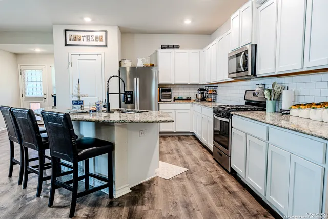 a kitchen with stainless steel appliances kitchen island granite countertop a sink and cabinets