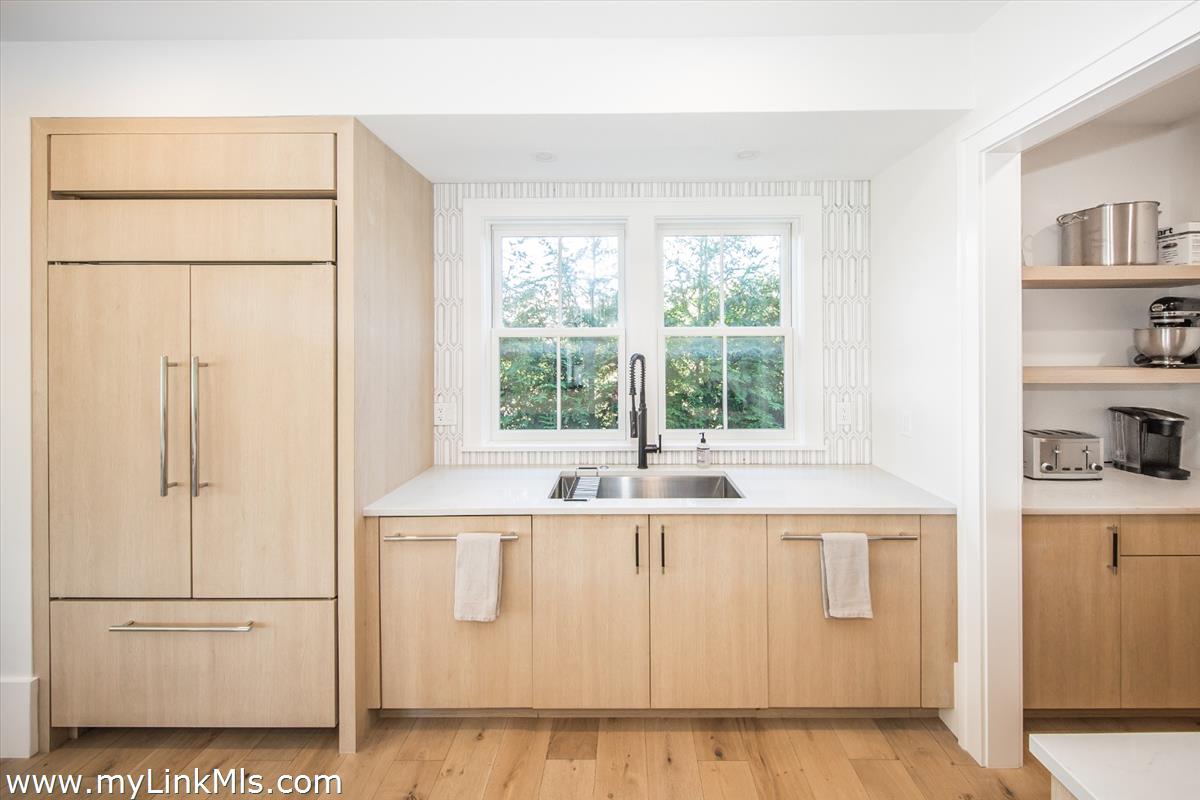 9 A Pilgrim Road Nantucket, MA 02554 - Photo 8 of 34 a kitchen with white cabinets and a window