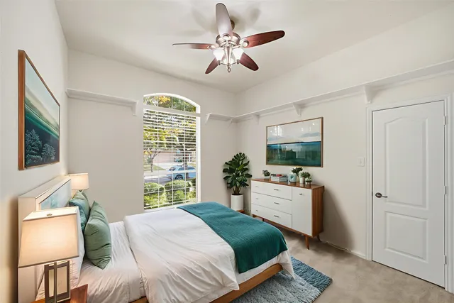 a bedroom with a bed and a large window