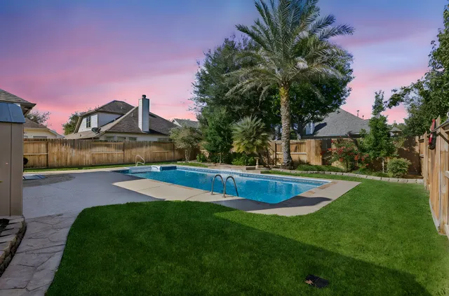 a view of a house with a swimming pool and a yard