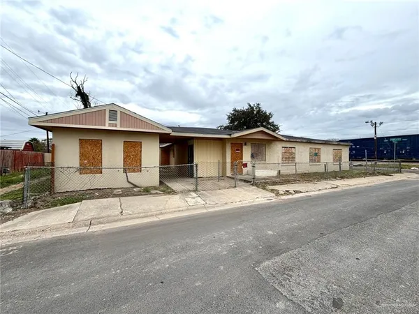 a front view of a house with a dirt yard and a garage