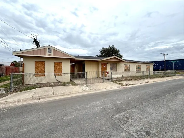 a front view of a house with a dirt yard and a garage