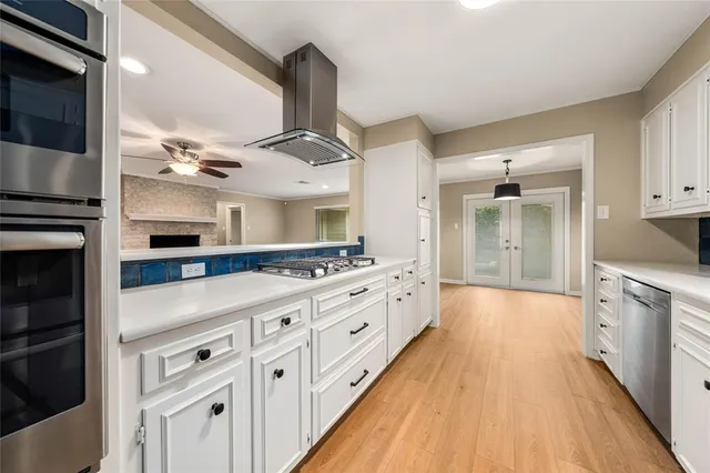 a kitchen with white cabinets and sink