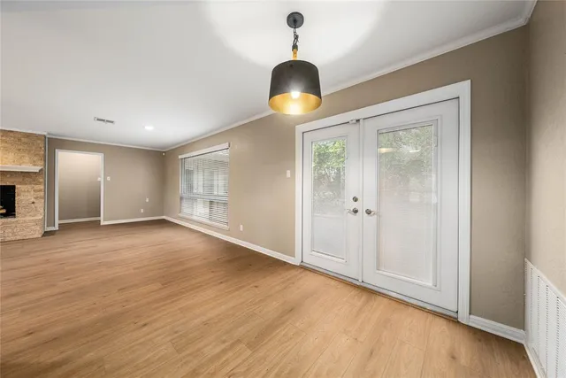a view of an empty room with a fireplace and a window