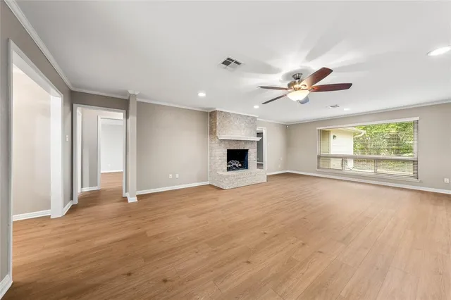 a view of a hallway with wooden floor and a bathroom